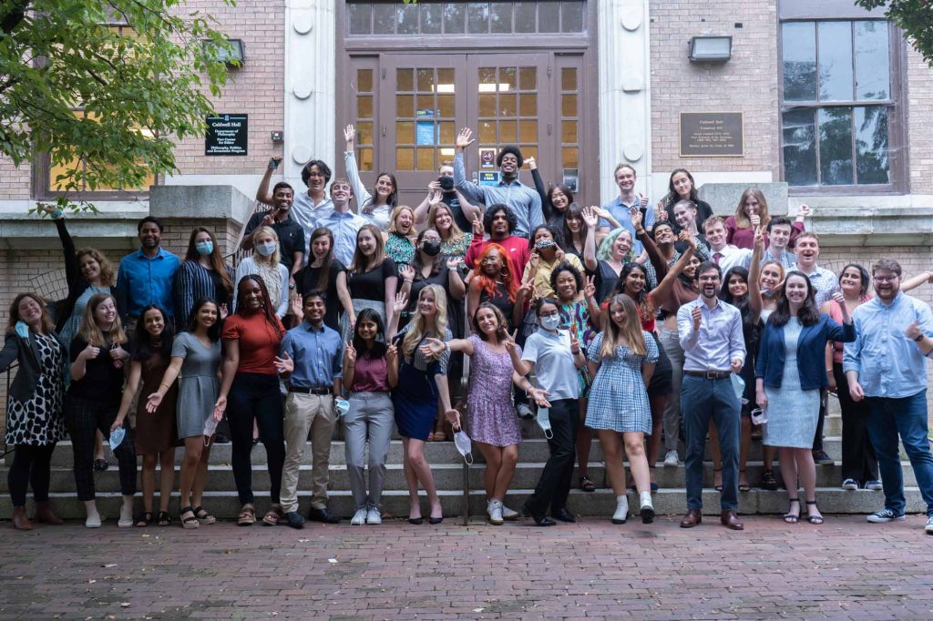 50+ Ethics Fellows posing for a silly picture on the steps of caldwell.